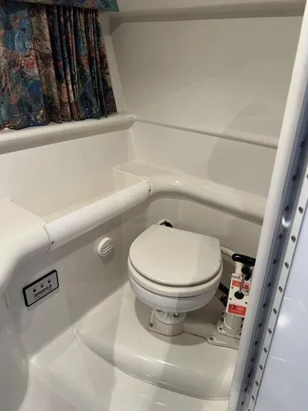 Slide: The Image of 1996 Formula 330 SS boat bathroom with white toilet and floral curtains. - 13