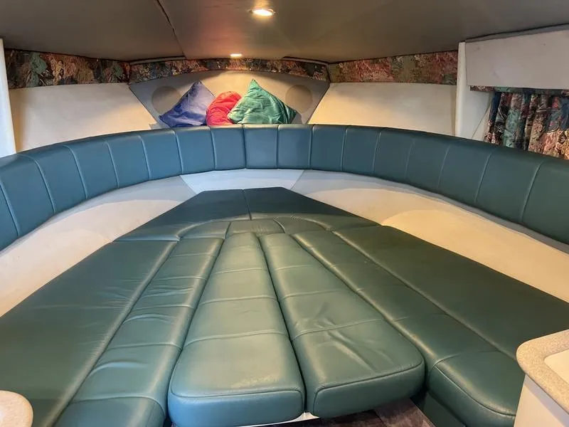 Slide: The Image of 1996 Formula 330 SS boat interior with teal seating and colorful cushions. - 14