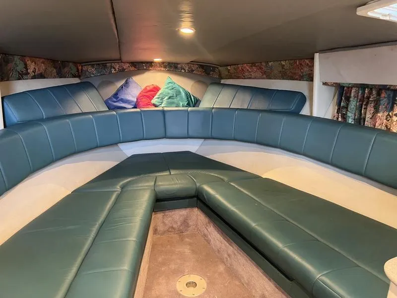 Slide: The Image of Interior of a 1996 Formula 330 SS boat with teal seating and colorful cushions. - 15