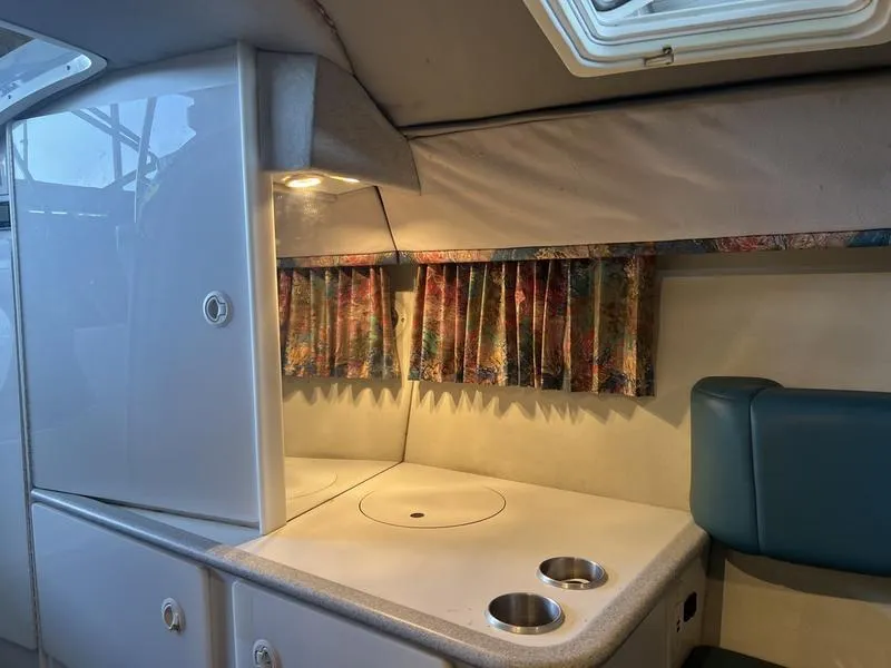 Slide: The Image of Interior of a 1996 Formula 330 SS boat with kitchenette and colorful curtains. - 16