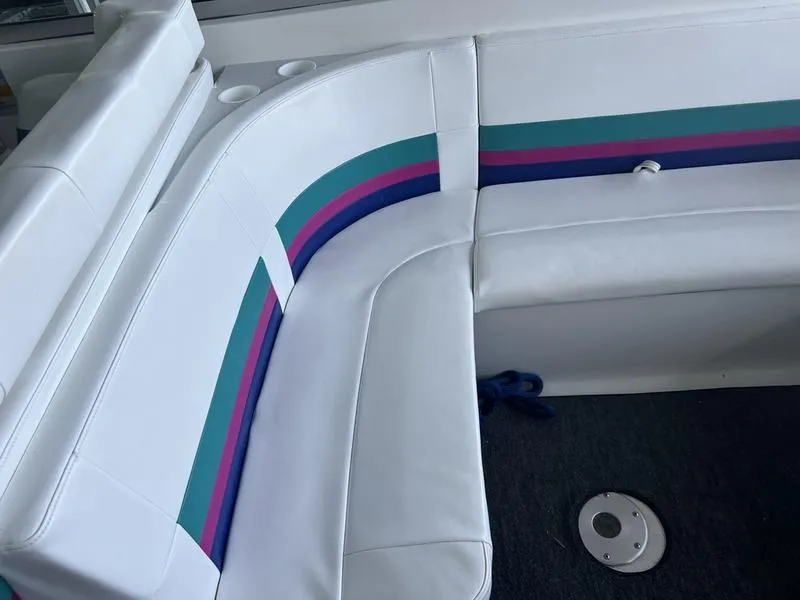 Slide: The Image of White leather seating with colorful stripes in a 1996 Formula 330 SS boat interior. - 6