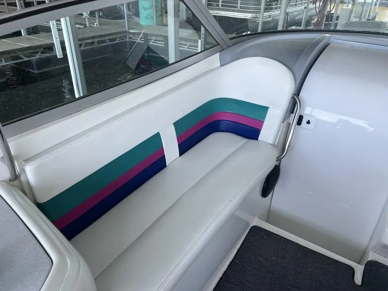 Slide: The Image of 1996 Formula 330 SS boat interior with white seating and colorful stripes. - 9