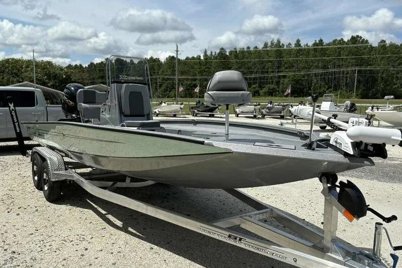 Slide: The Image of 2026 Xpress H22 Bay boat on trailer, parked outdoors under cloudy sky. - 1