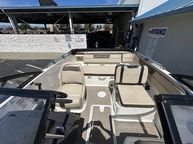 Slide: The Image of 2017 Bayliner VR5 Bowrider interior with beige seating and steering wheel, parked outdoors. - 36