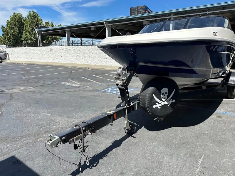 Slide: The Image of 2017 Bayliner VR5 Bowrider on trailer with pirate-themed tire cover in parking lot. - 4