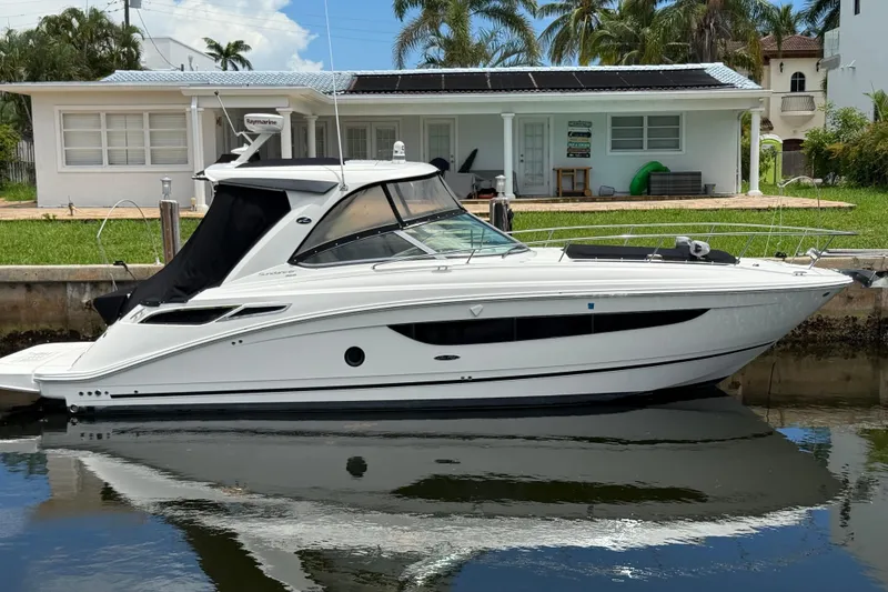 The Image of 2016 Sea Ray 350 Sundancer yacht docked by a waterfront house. - 0