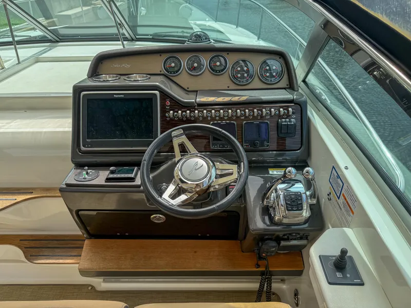 Slide: The Image of Cockpit of 2016 Sea Ray 350 Sundancer with steering wheel and control panel. - 12