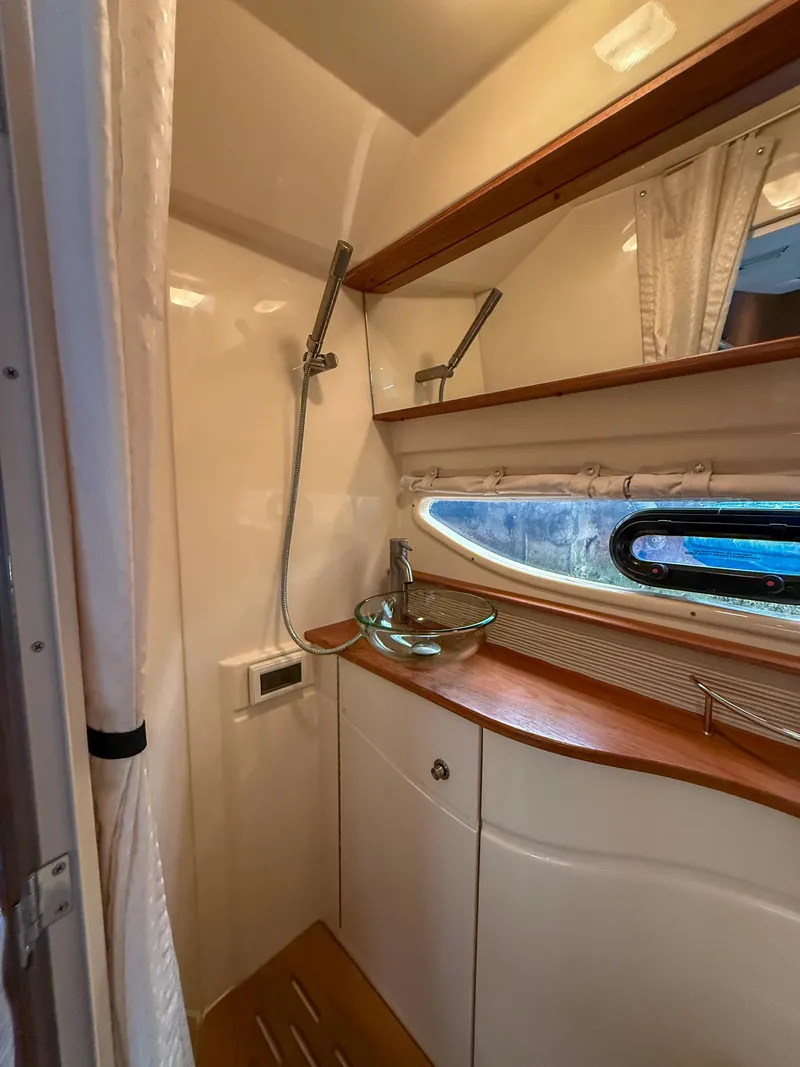 Slide: The Image of 2016 Sea Ray 350 Sundancer bathroom with glass sink and wooden countertop. - 25
