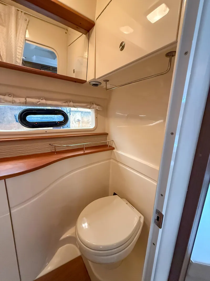 Slide: The Image of 2016 Sea Ray 350 Sundancer bathroom with modern fixtures and wood accents. - 26
