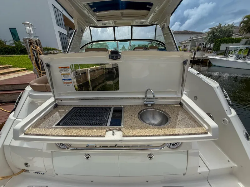 Slide: The Image of 2016 Sea Ray 350 Sundancer boat with outdoor kitchenette, featuring a sink and grill. - 4