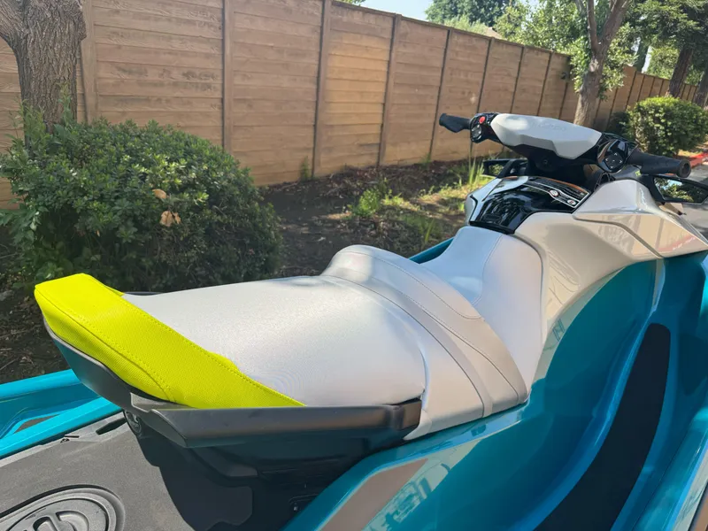 Slide: The Image of 2025 Sea-Doo GTI SE 170 jet ski with vibrant seat, parked outdoors. - 2