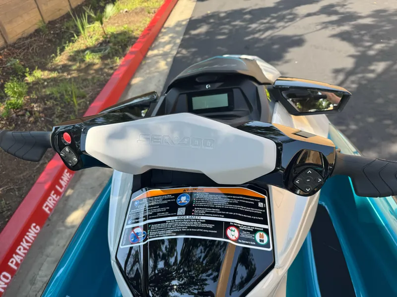 Slide: The Image of 2025 Sea-Doo GTI SE 170 jet ski handlebars and dashboard, parked on a sunny day. - 5