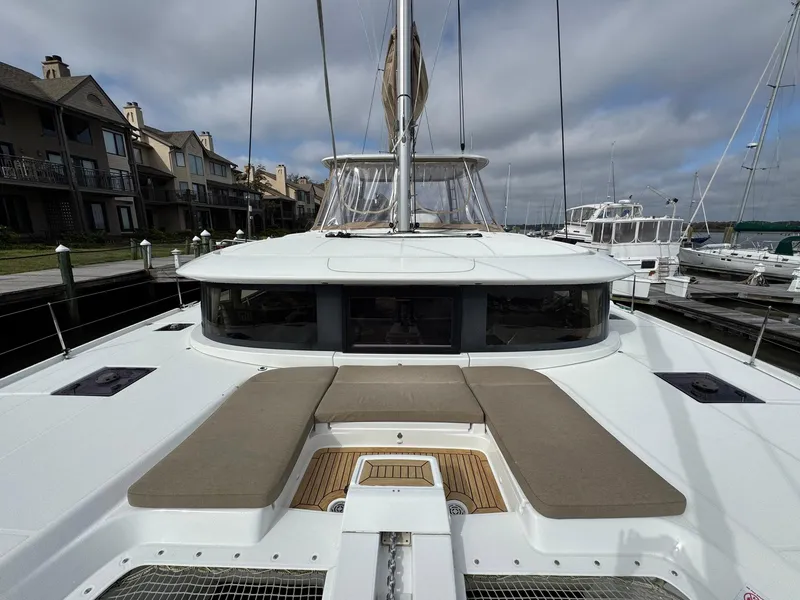 Slide: The Image of Lagoon 46 catamaran, 2022 model, docked at marina with spacious deck and seating area. - 11