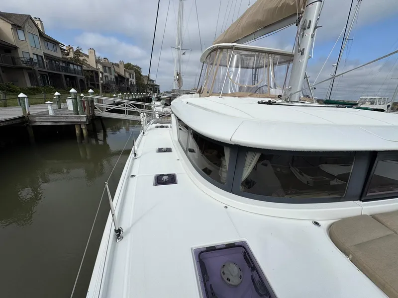 Slide: The Image of 2022 Lagoon 46 catamaran docked at marina, showcasing sleek design and spacious deck. - 18