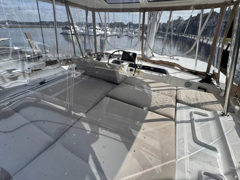 Slide: The Image of 2022 Lagoon 46 yacht interior with spacious seating and marina view. - 25