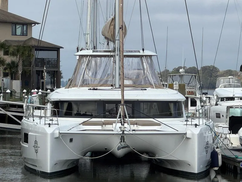 Slide: The Image of 2022 Lagoon 46 catamaran docked at marina, front view, overcast sky. - 3