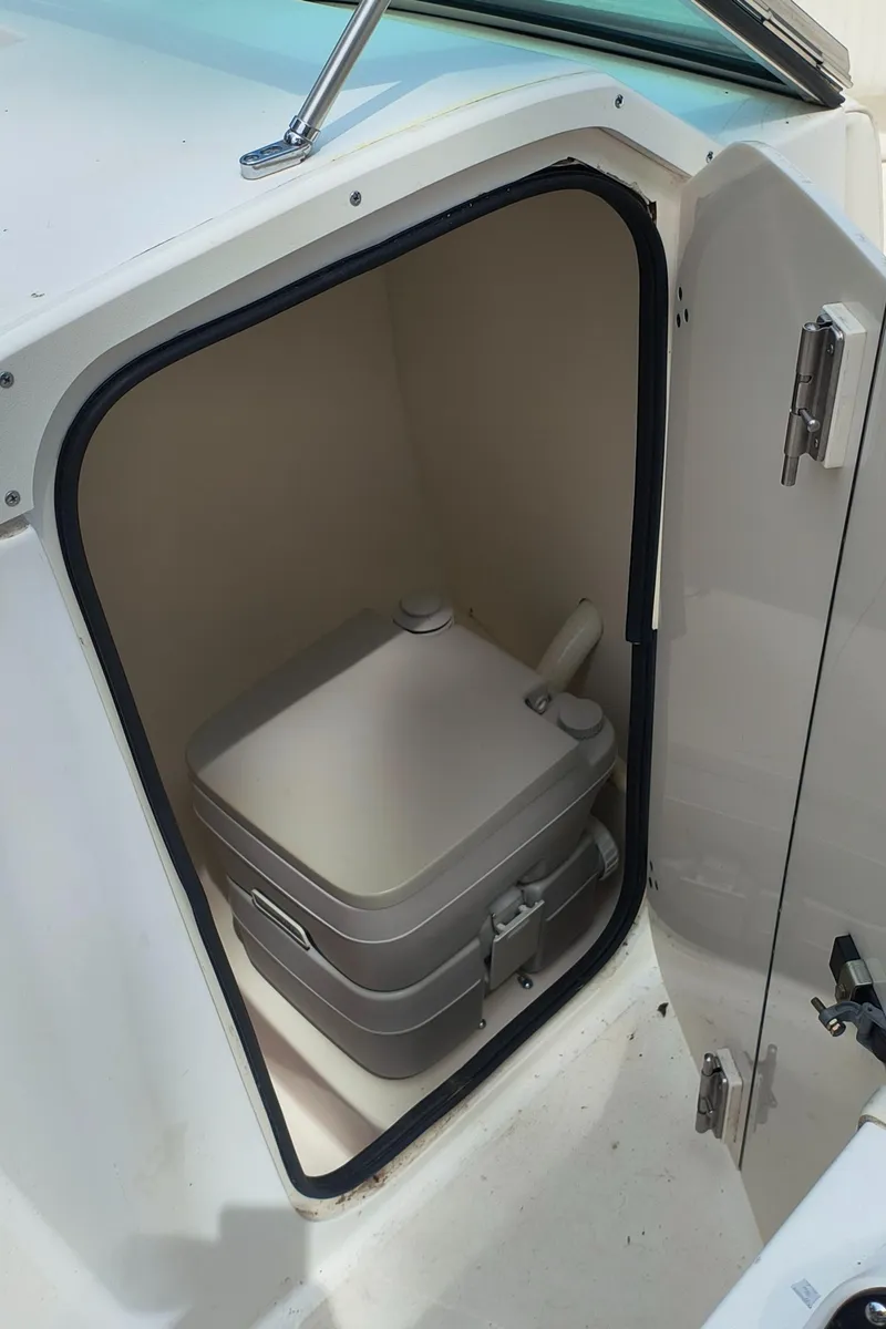 Slide: The Image of Portable toilet inside a 2001 Boston Whaler 210 Ventura boat compartment. - 10
