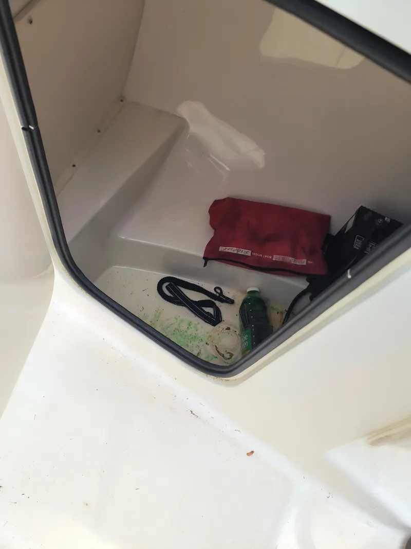 Slide: The Image of Storage compartment of a 2001 Boston Whaler 210 Ventura with items inside. - 11