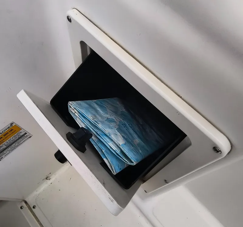 Slide: The Image of Storage compartment with a folded map inside a 2001 Boston Whaler 210 Ventura boat. - 17