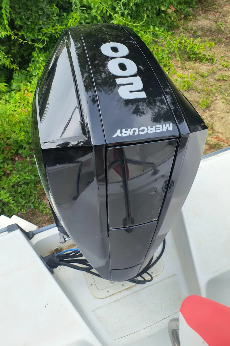 Slide: The Image of Mercury 100 outboard motor on 2001 Boston Whaler 210 Ventura boat, surrounded by greenery. - 18