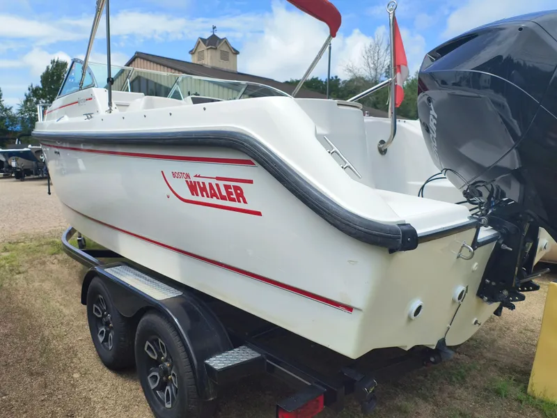 Slide: The Image of 2001 Boston Whaler 210 Ventura boat on trailer, featuring outboard motor and red branding. - 2