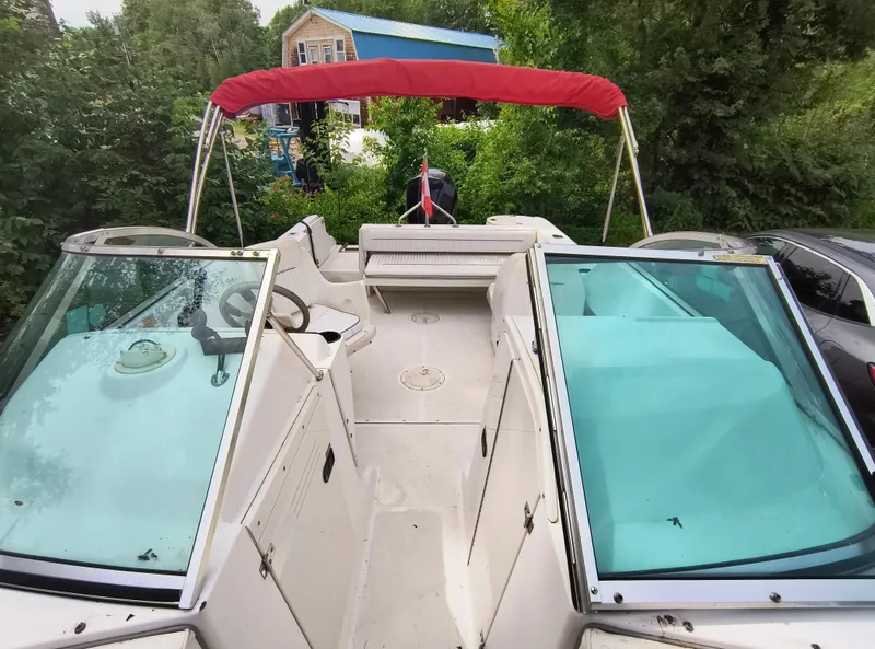 Slide: The Image of 2001 Boston Whaler 210 Ventura boat with red canopy, parked outdoors. - 3