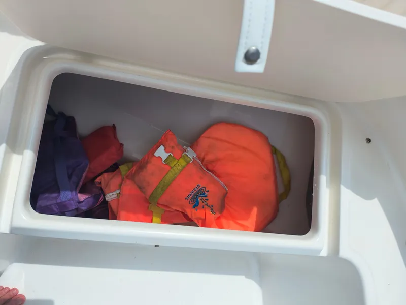 Slide: The Image of Storage compartment with life jackets on a 2001 Boston Whaler 210 Ventura boat. - 6
