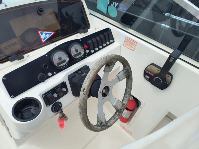 Slide: The Image of 2001 Boston Whaler 210 Ventura boat dashboard with steering wheel and control panel. - 9