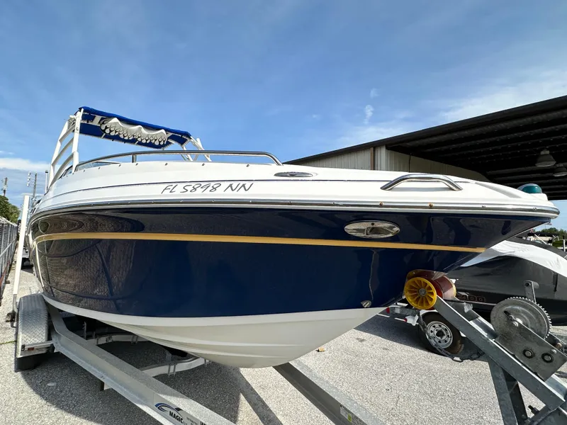 Slide: The Image of 2007 Ebbtide 2460 SS Fun Cruiser DC on trailer, blue and white design. - 2