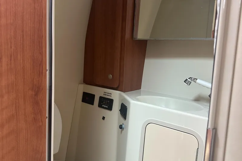 Slide: The Image of 2009 Cruisers 300 CXi Express boat bathroom with sink and wooden cabinet. - 16