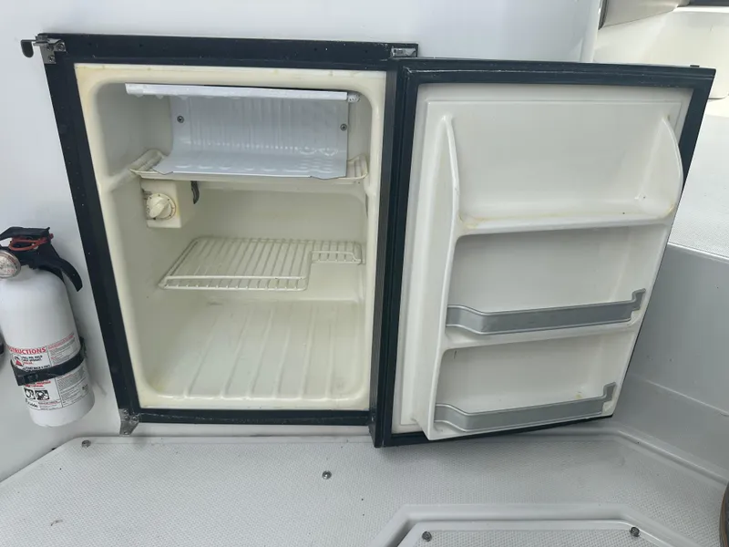 Slide: The Image of Open mini fridge on 2009 Cruisers 300 CXi Express boat with fire extinguisher nearby. - 5