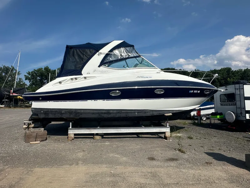 The Image of 2009 Cruisers 300 CXi Express boat on dry dock under clear blue sky. - 0