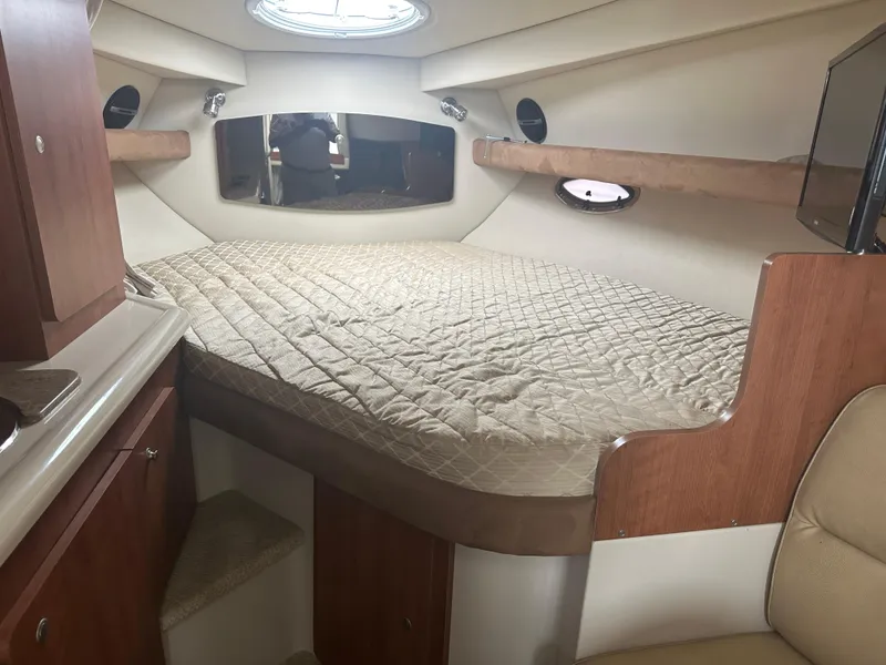Slide: The Image of 2009 Cruisers 300 CXi Express cabin interior with bed and wood accents. - 11