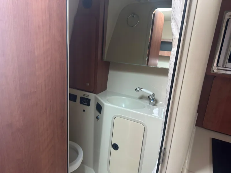 Slide: The Image of 2009 Cruisers 300 CXi Express boat bathroom with sink, mirror, and wooden cabinetry. - 17