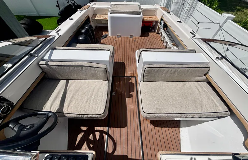 Slide: The Image of 2010 Westport 23 Custom Tender interior with cushioned seating and wooden deck. - 15