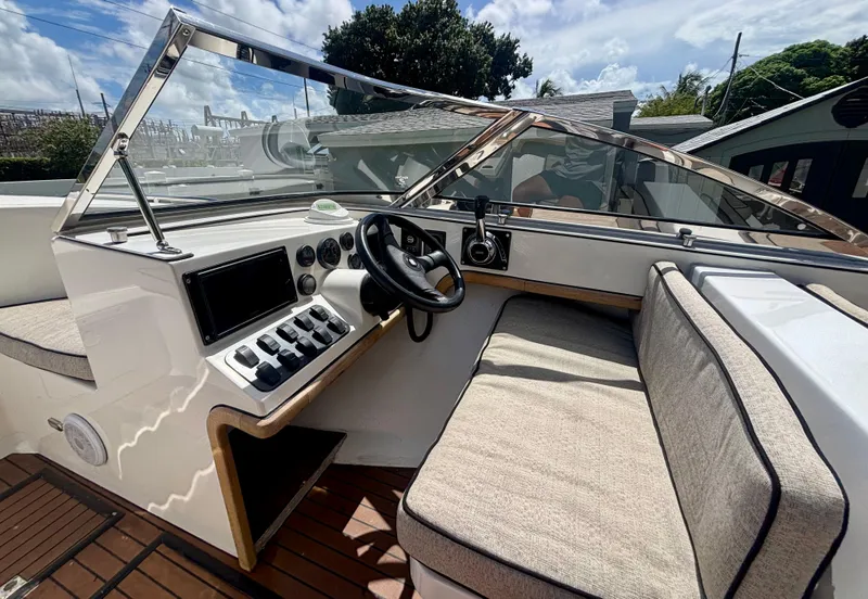 Slide: The Image of Interior of 2010 Westport 23 Custom Tender, featuring steering wheel and control panel. - 16