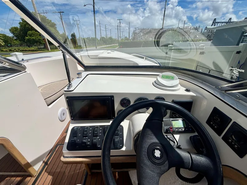 Slide: The Image of 2010 Westport 23 Custom Tender dashboard with steering wheel and navigation controls. - 17