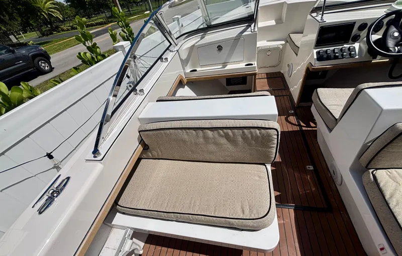Slide: The Image of 2010 Westport 23 Custom Tender interior with cushioned seating and wooden flooring. - 27