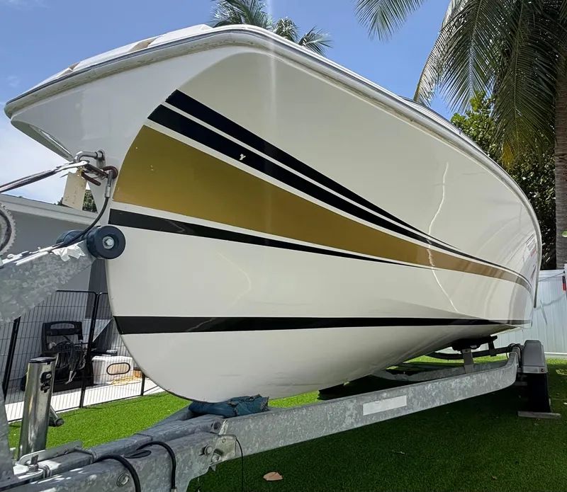 Slide: The Image of 2010 Westport 23 Custom Tender on trailer, featuring sleek gold and black stripes. - 3