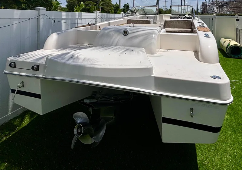 Slide: The Image of 2010 Westport 23 Custom Tender boat on grass, rear view, white hull, dual propellers. - 5
