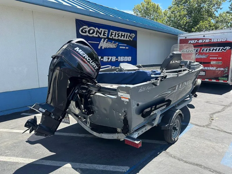 Slide: The Image of 2015 Lund 1625 Fury XL SS boat with Mercury engine on trailer, parked outside dealership. - 8