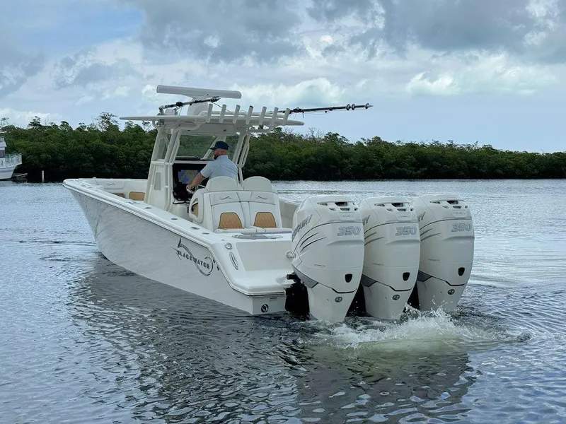 Slide: The Image of 2021 Blackwater 36 Sport boat cruising on open water under clear blue skies. - 4