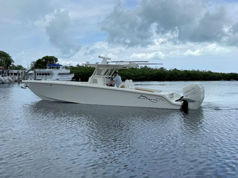 Slide: The Image of 2021 Blackwater 36 Sport boat cruising on open water under clear blue sky. - 6