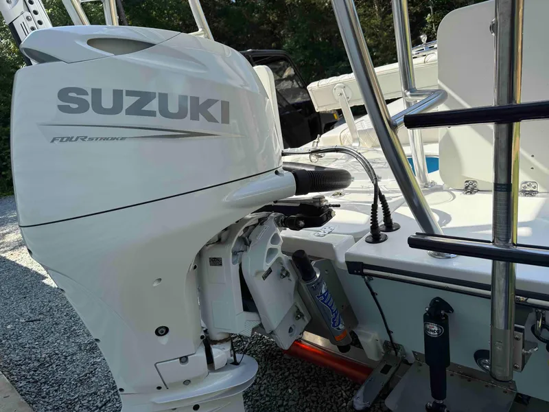 Slide: The Image of 2022 Beavertail Skiffs Vengeance with Suzuki four-stroke outboard motor, parked on gravel. - 25