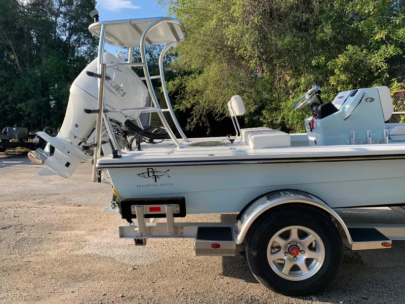 Slide: The Image of 2022 Beavertail Skiffs Vengeance boat on trailer, parked outdoors with trees in background. - 3