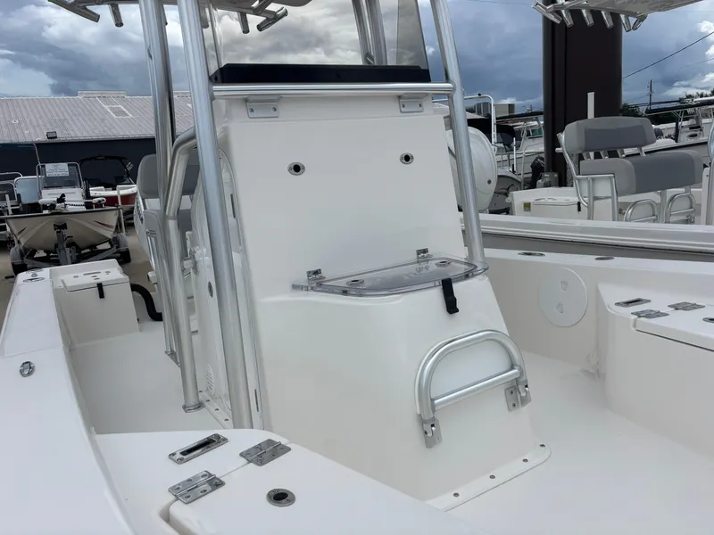 Slide: The Image of 2026 Bay Rider 219 Bay boat interior with seating and storage, under cloudy sky. - 12