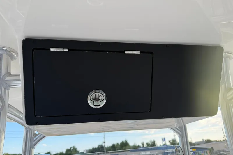Slide: The Image of 2026 Bay Rider 219 Bay boat storage compartment with secure latch. - 23
