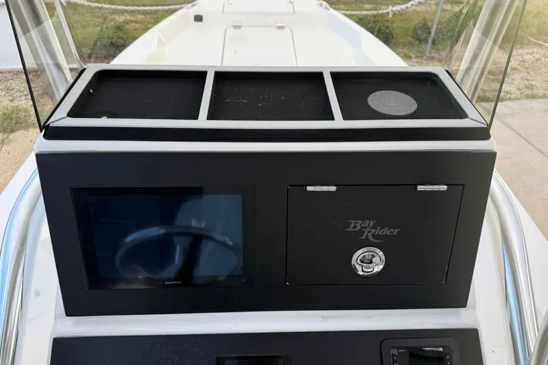 Slide: The Image of 2026 Bay Rider 219 Bay console with Garmin display and storage compartment. - 24