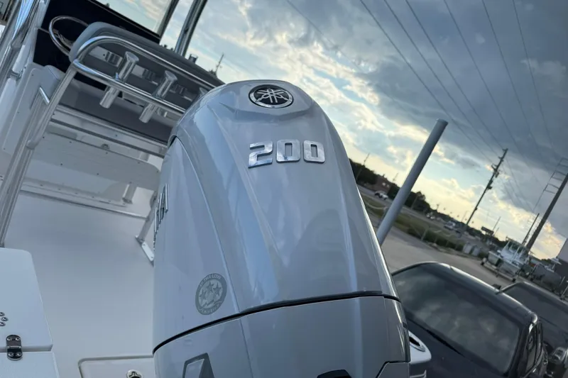 Slide: The Image of 2026 Bay Rider 219 Bay boat with Yamaha 200 outboard motor, parked under cloudy sky. - 33