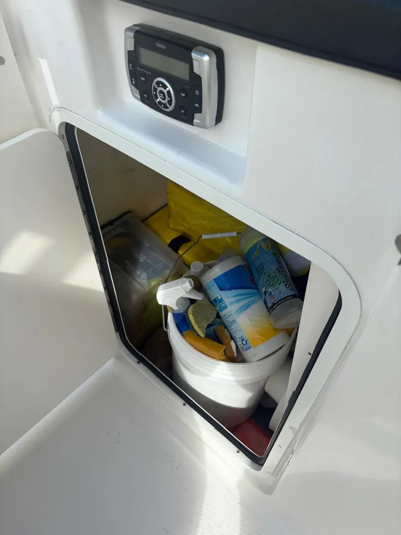 Slide: The Image of 2021 Robalo R247 Dual Console boat interior with windshield and storage compartment. - 12